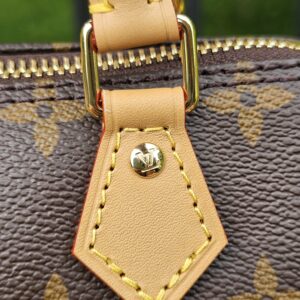 Close-up of the gold-tone zip pull and vachetta leather tab on the Louis Vuitton Nano Speedy Bandouliere