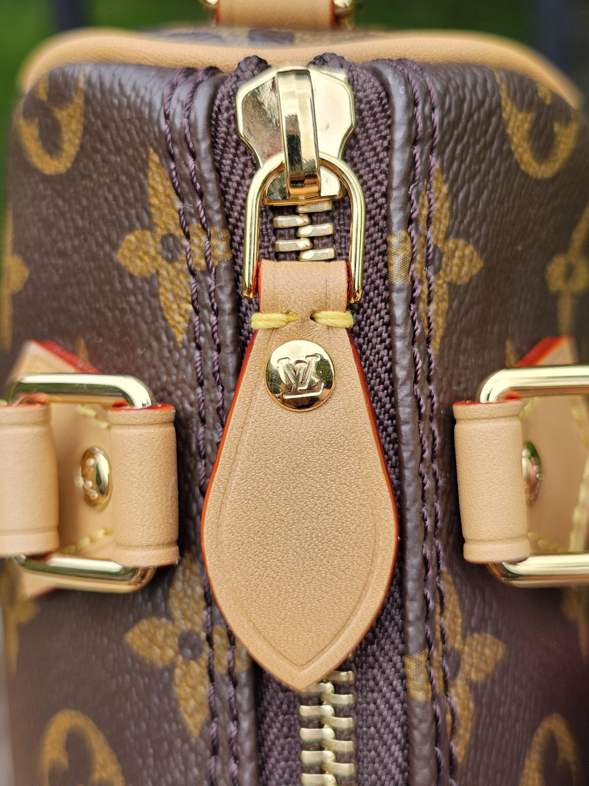 Top of the Louis Vuitton Nano Speedy Bandouliere with the gold-tone zip closed and both leather pulls together