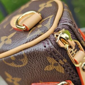 Top corner of the Louis Vuitton Nano Speedy Bandouliere showing gold-tone hardware and vachetta piping
