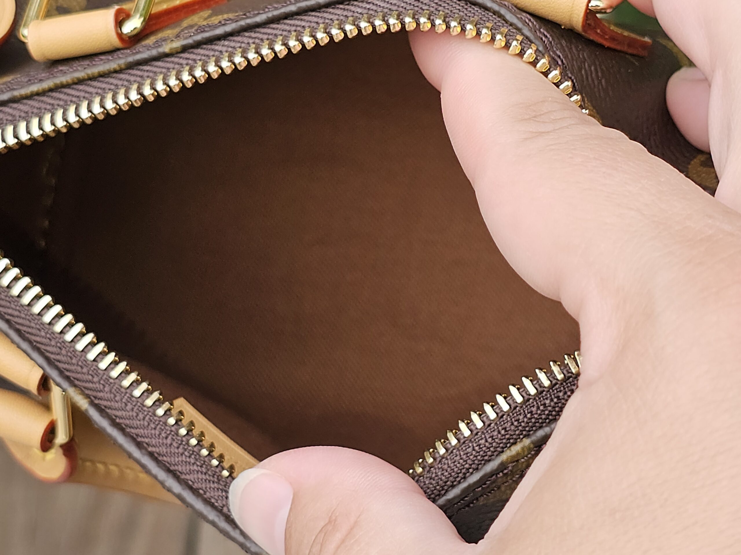 Interior of the Louis Vuitton Nano Speedy Bandouliere showing the clean brown textile lining through the open zip