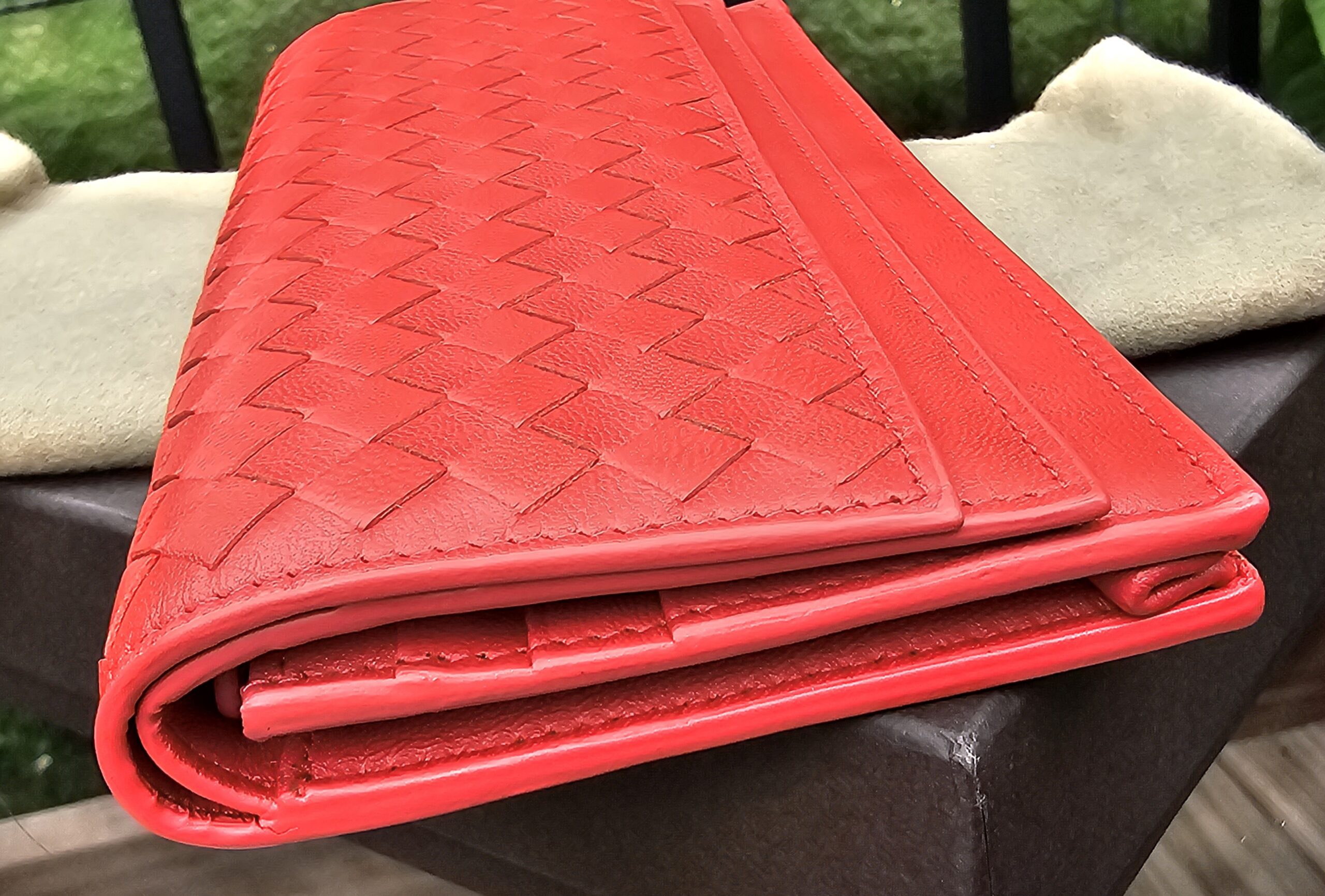 Side profile of the Bottega Veneta Intrecciato continental wallet showing its depth