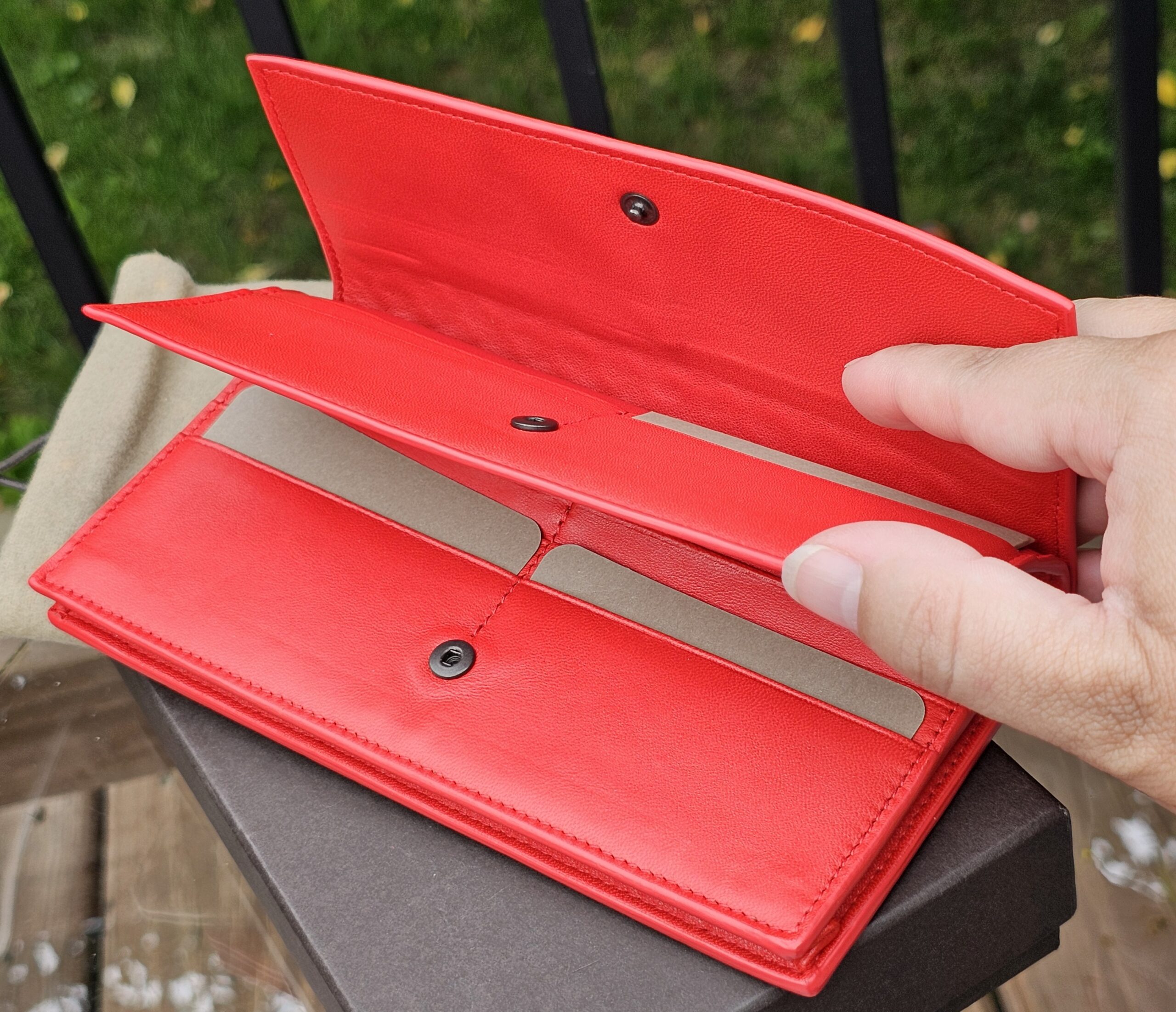 Snap flap closure of the Bottega Veneta Intrecciato continental wallet