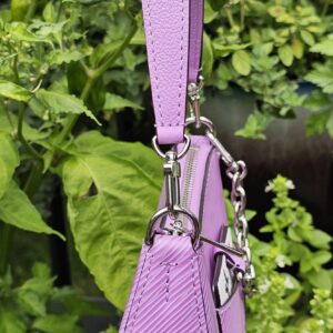 Louis Vuitton Epi Marellini in purple held by its strap to show scale