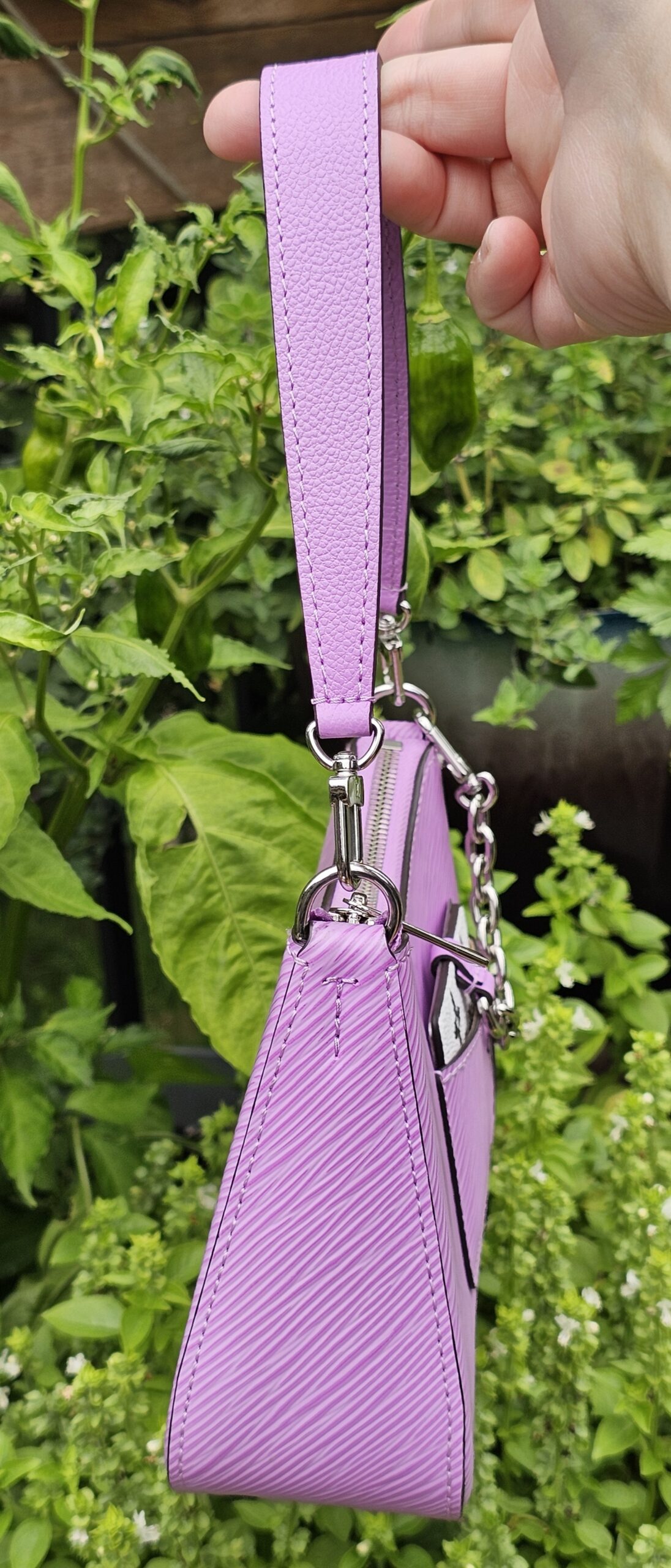 Louis Vuitton Epi Marellini in purple held by its strap to show scale