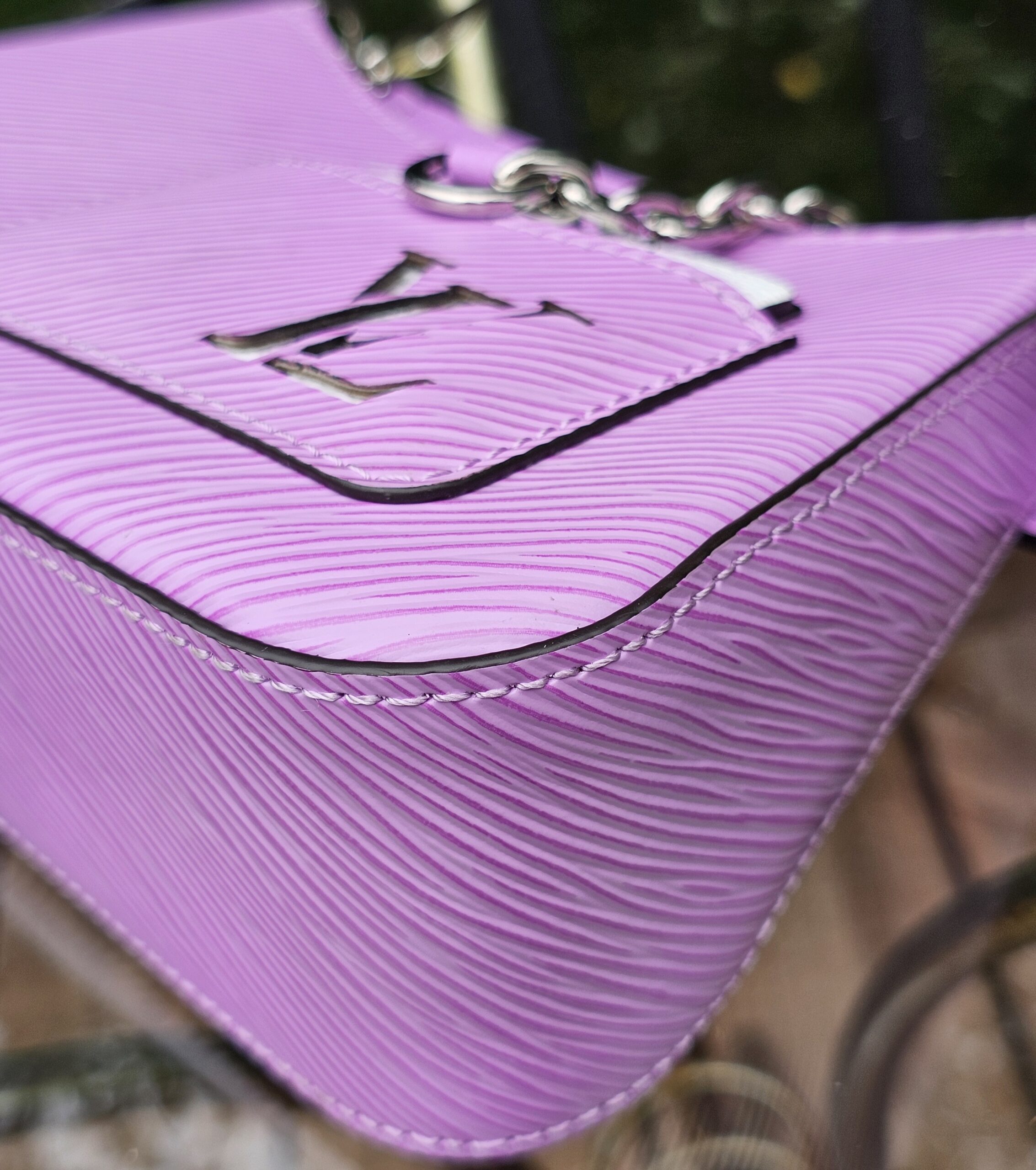 Silver-tone LV plaque on the front panel of the Louis Vuitton Epi Marellini