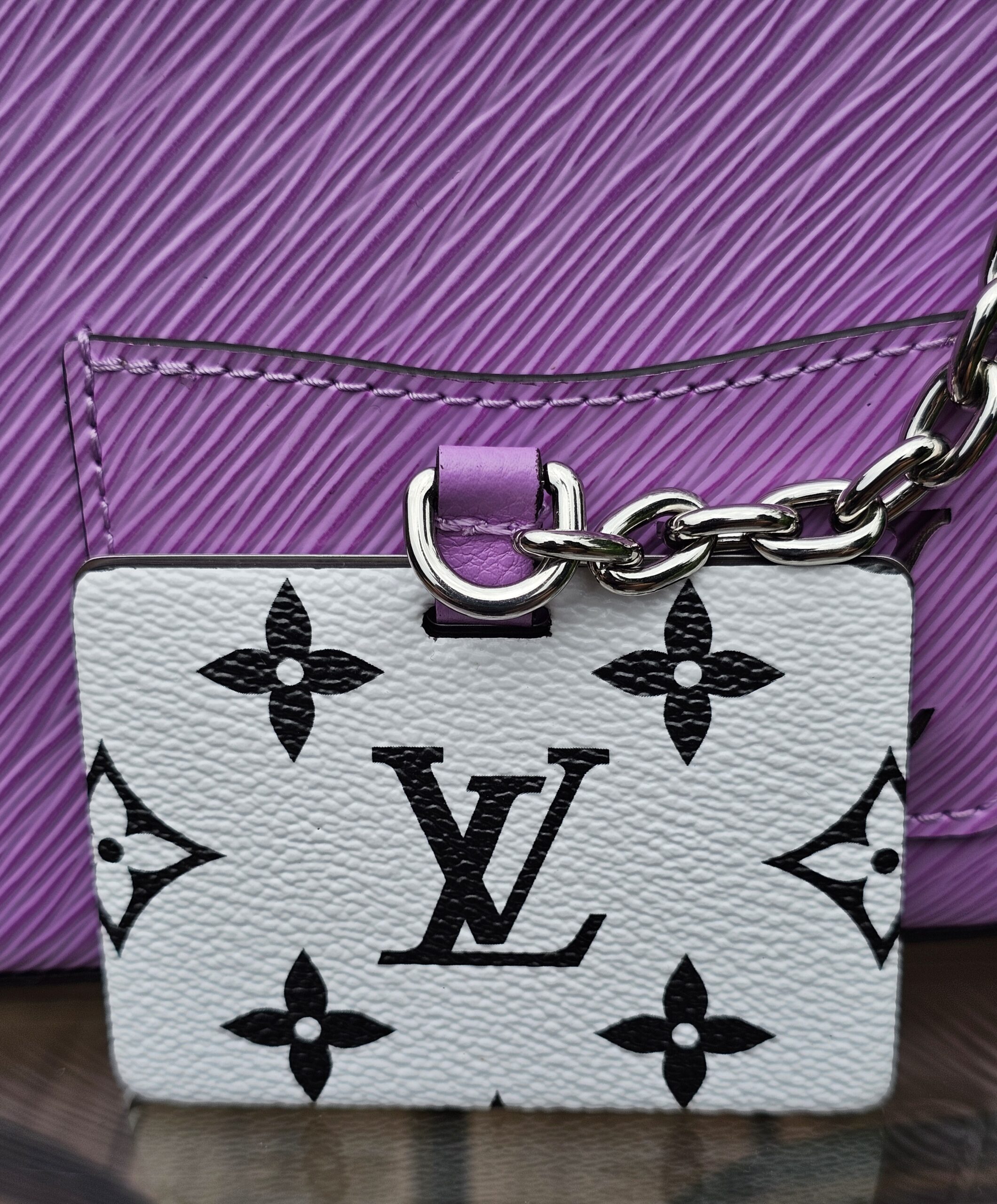 Contrasting Monogram front pocket and silver chain on the Louis Vuitton Epi Marellini
