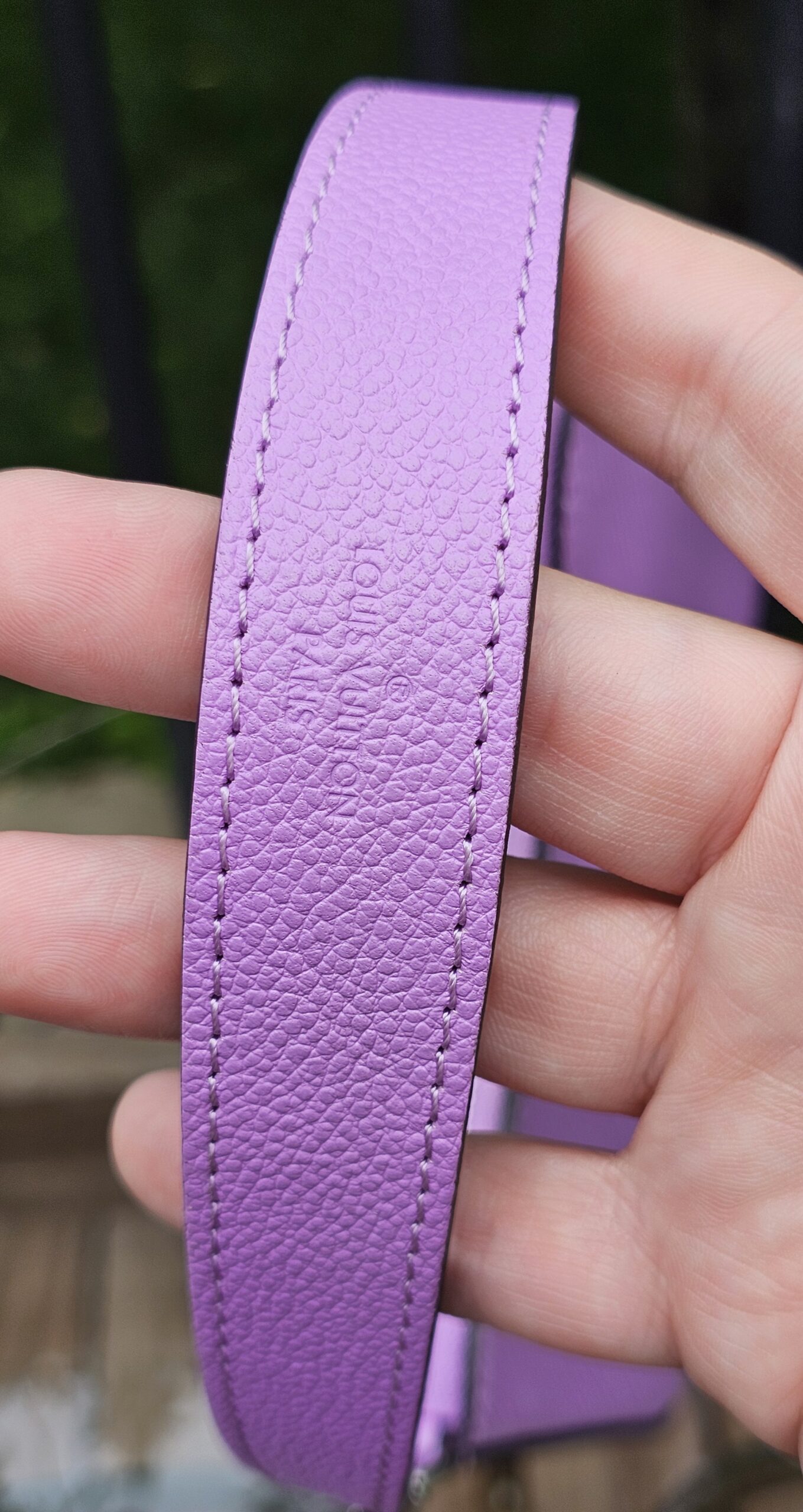 Purple Epi leather shoulder strap for the Louis Vuitton Marellini held in hand