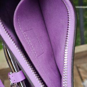 Interior seams and lining of the Louis Vuitton Epi Marellini in purple