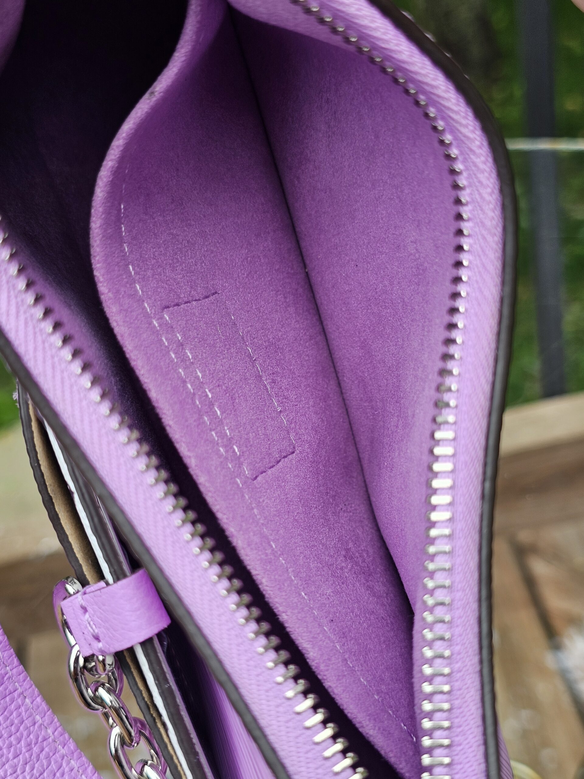Interior seams and lining of the Louis Vuitton Epi Marellini in purple