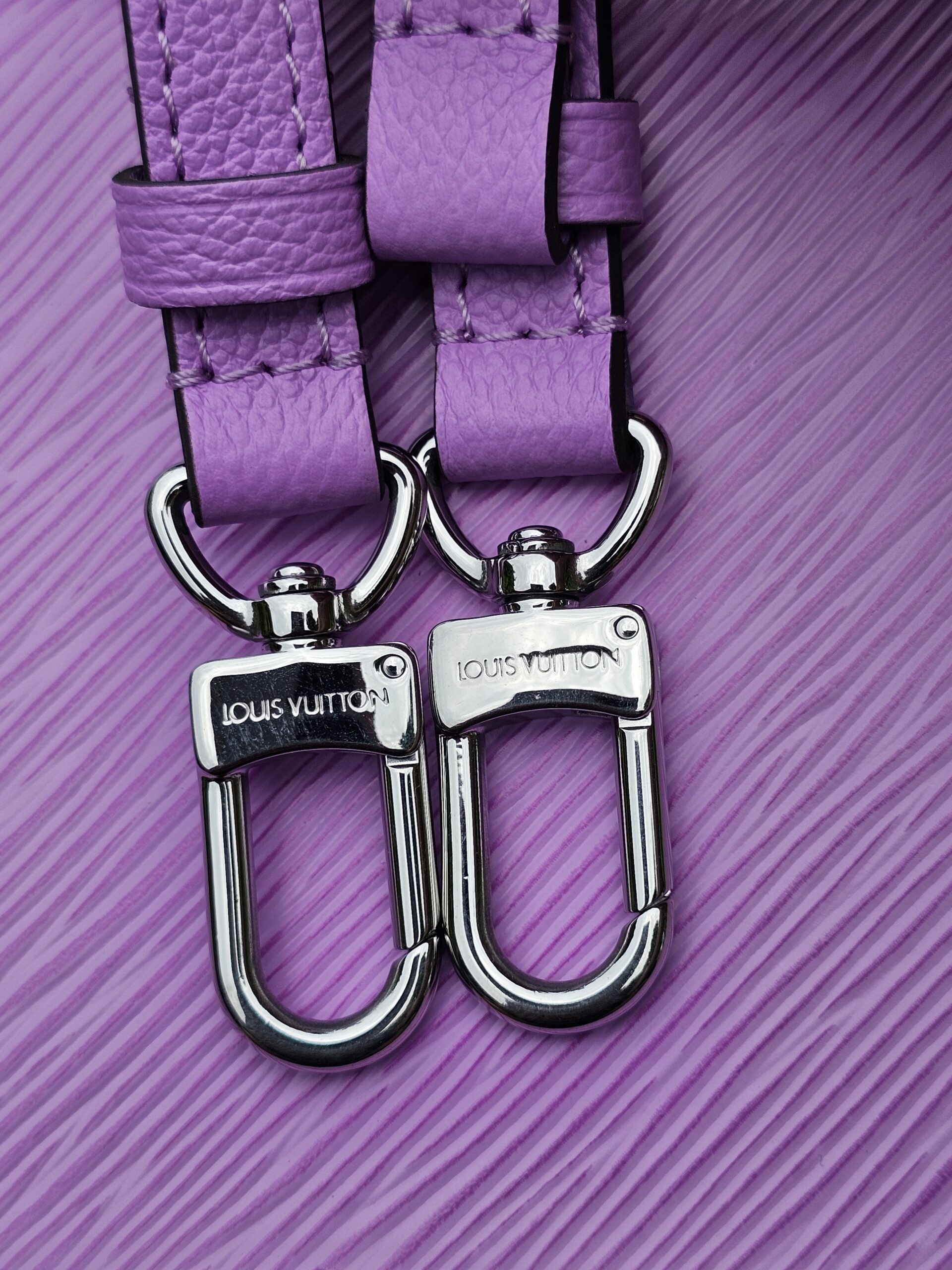 Silver-tone clasps stamped Louis Vuitton on the Epi Marellini shoulder strap