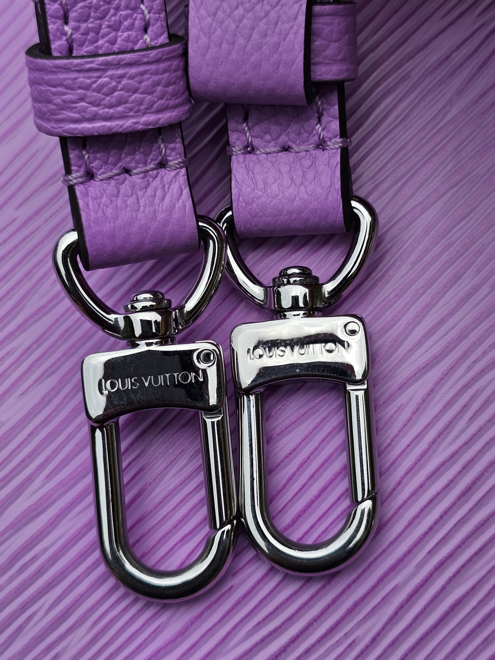 Close-up of the silver-tone strap clasps on the Louis Vuitton Epi Marellini