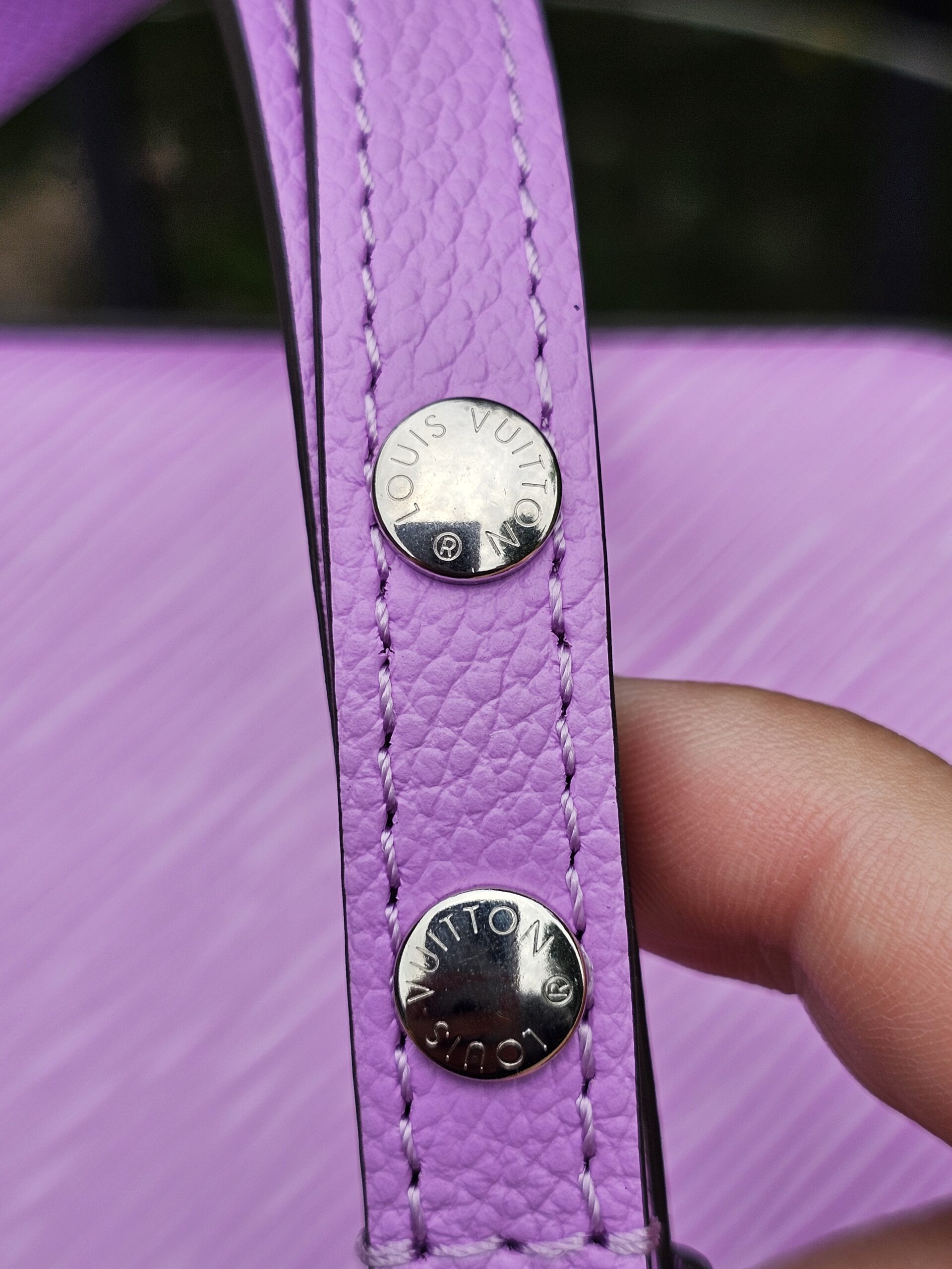 Silver-tone studs on the adjustable Epi leather strap of the Louis Vuitton Marellini