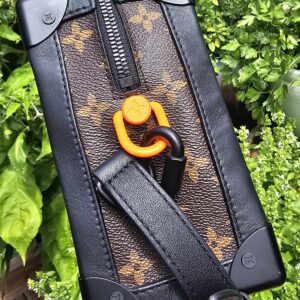 Bright orange Solar Ray carabiner and black hardware on the Louis Vuitton Soft Trunk