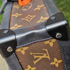 Black corner protector on the Louis Vuitton Solar Ray Soft Trunk showing scratches from use