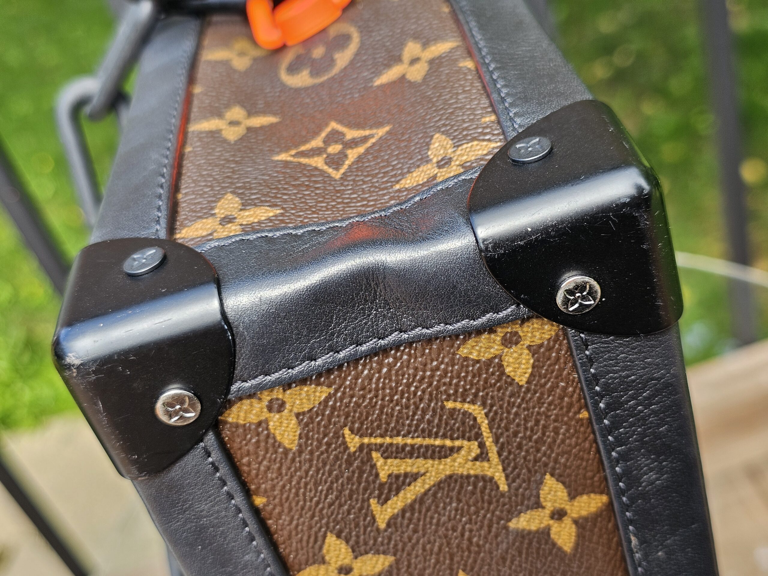 Black corner protector on the Louis Vuitton Solar Ray Soft Trunk showing scratches from use