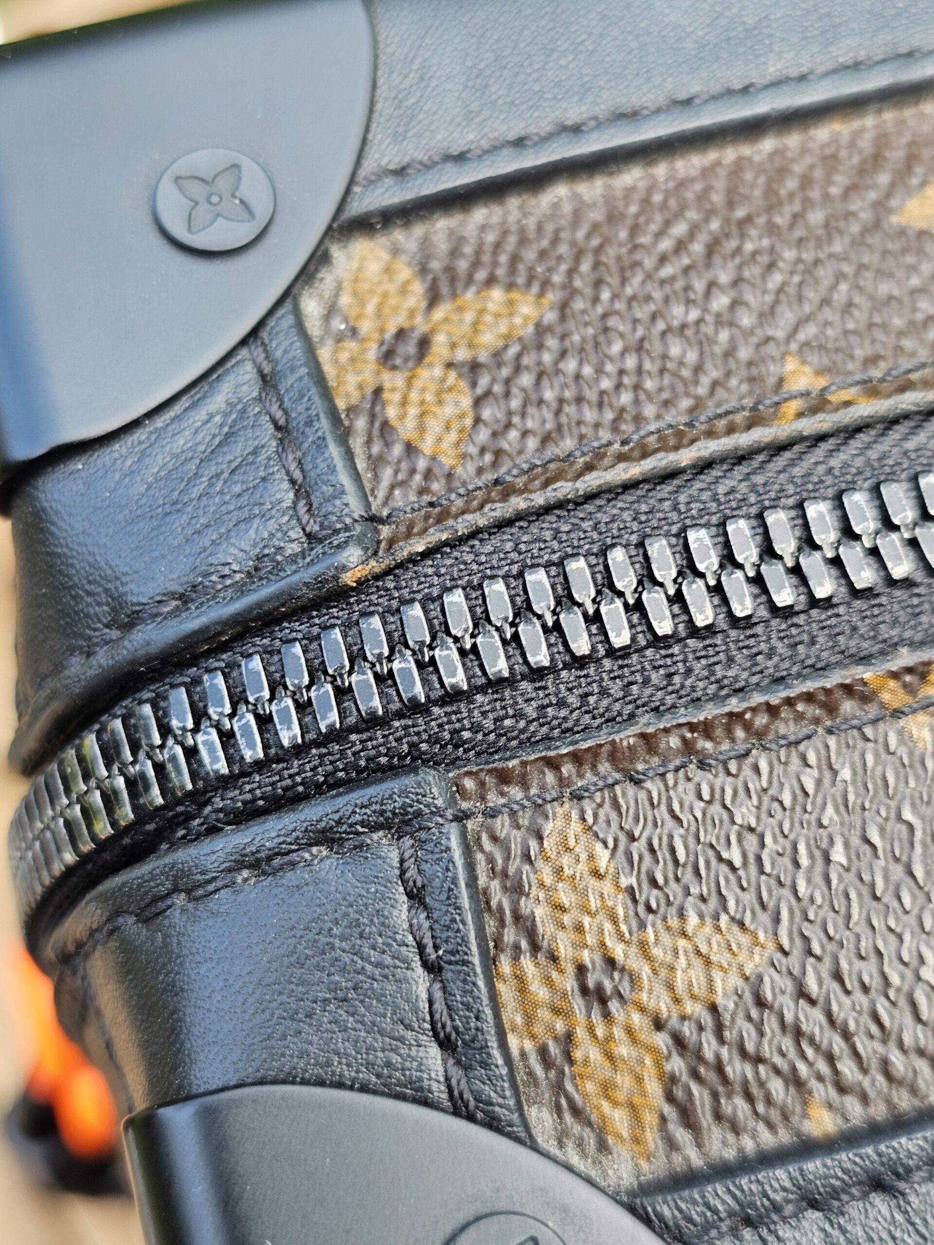 Close-up of the zip track and black leather trim on the Louis Vuitton Solar Ray Soft Trunk
