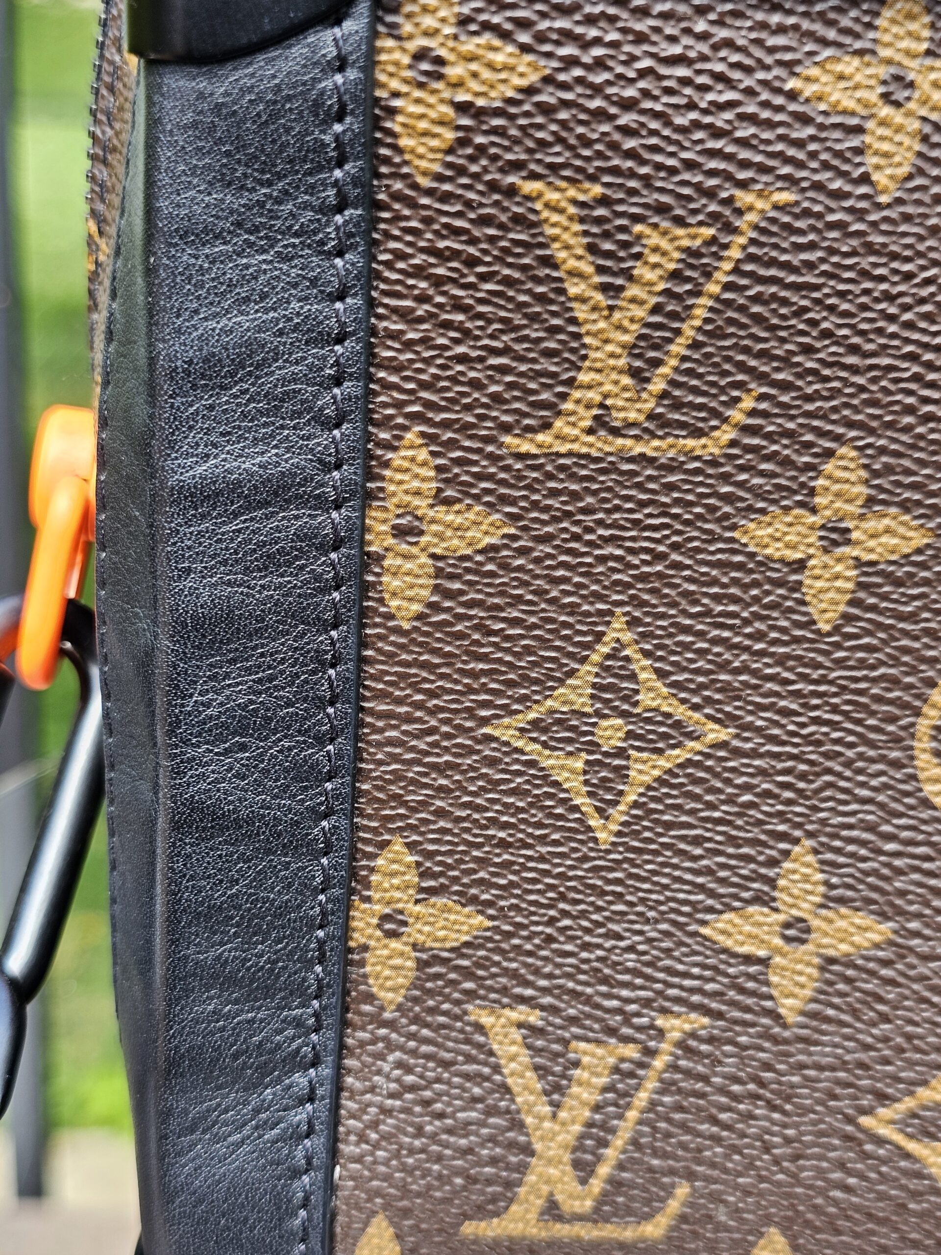 Side panel of the Louis Vuitton Monogram Solar Ray Soft Trunk with the orange accent visible