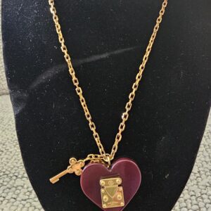 Louis Vuitton Lock Me heart necklace with burgundy resin heart, gold-tone S-lock and key charm on a gold chain