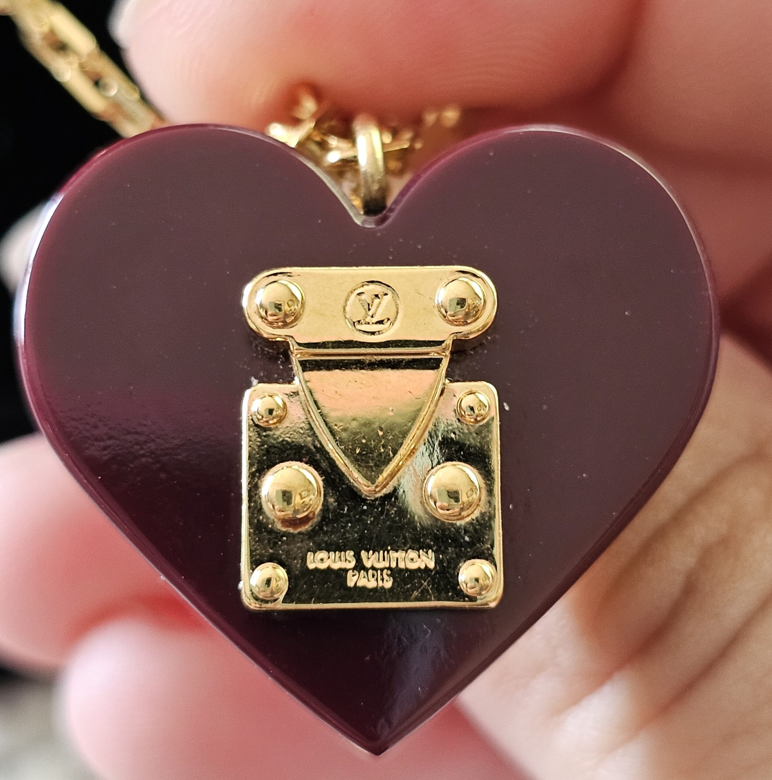 Gold-tone S-lock on the burgundy heart pendant stamped Louis Vuitton Paris