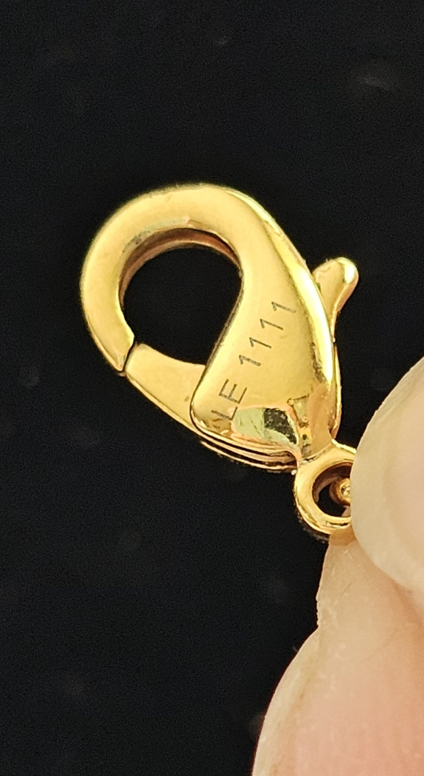 Gold-tone lobster clasp stamped LE1111 on the Louis Vuitton Lock Me heart necklace