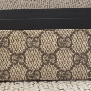 Front of the Gucci GG Supreme Essence card holder showing the GG canvas and black leather card slots