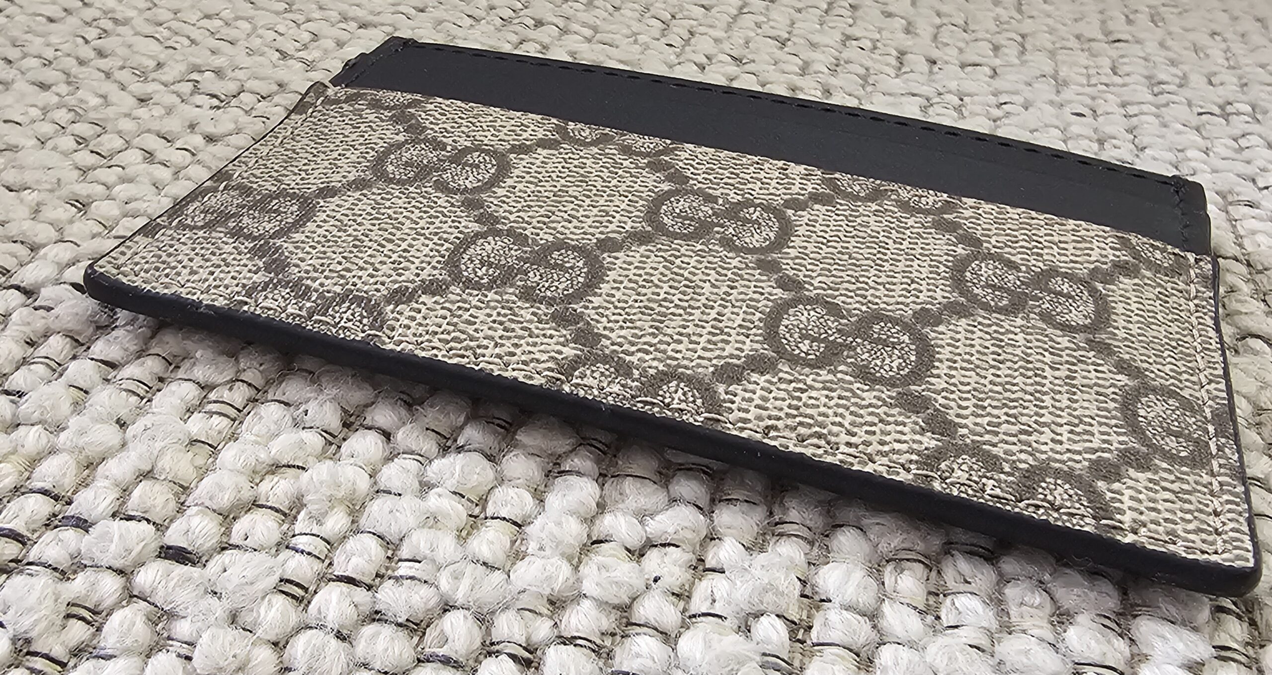 Back of the Gucci Essence card holder in GG Supreme canvas with a black leather slot