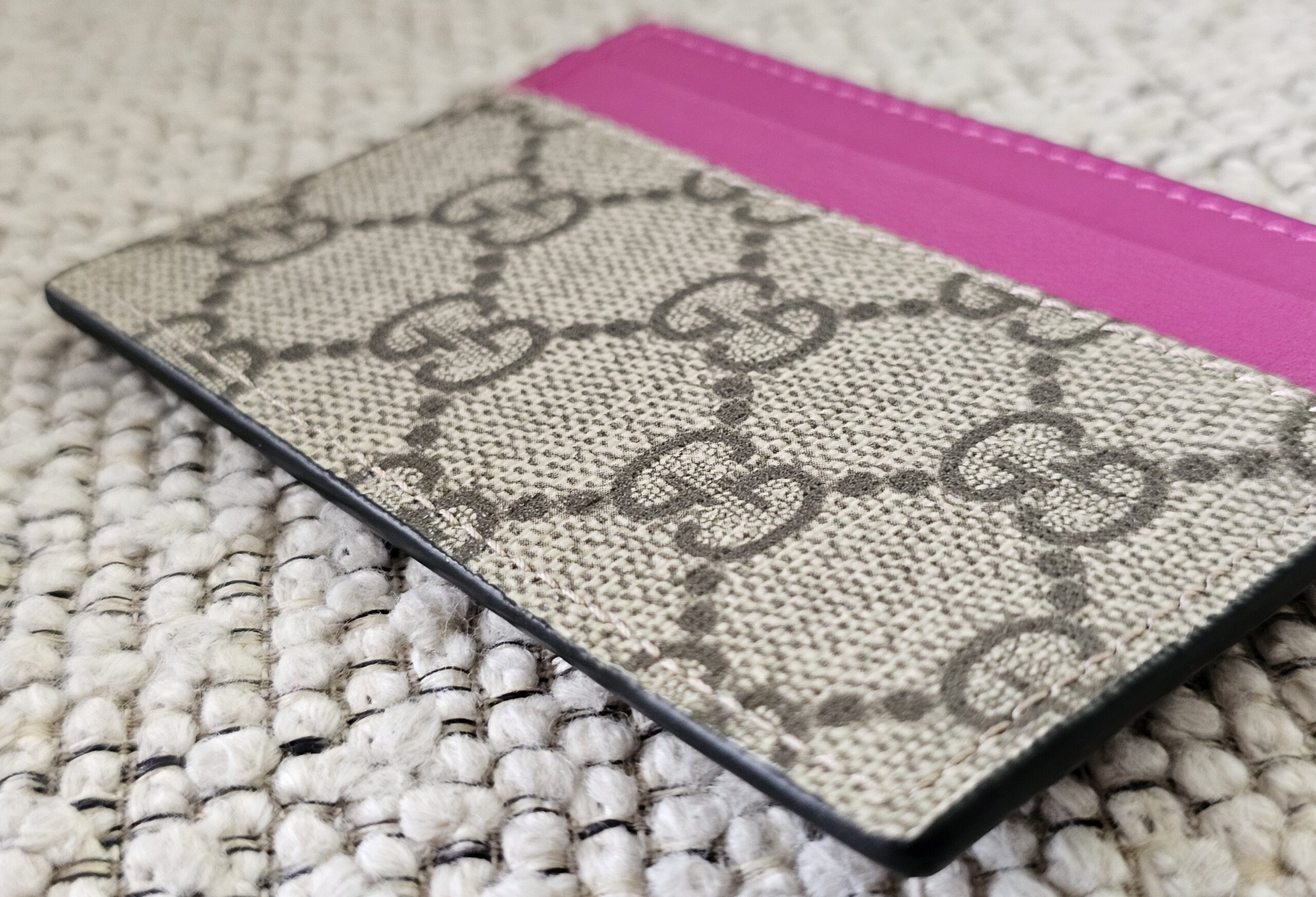 Back of the Gucci Essence card holder in GG Supreme canvas with a pink calfskin slot