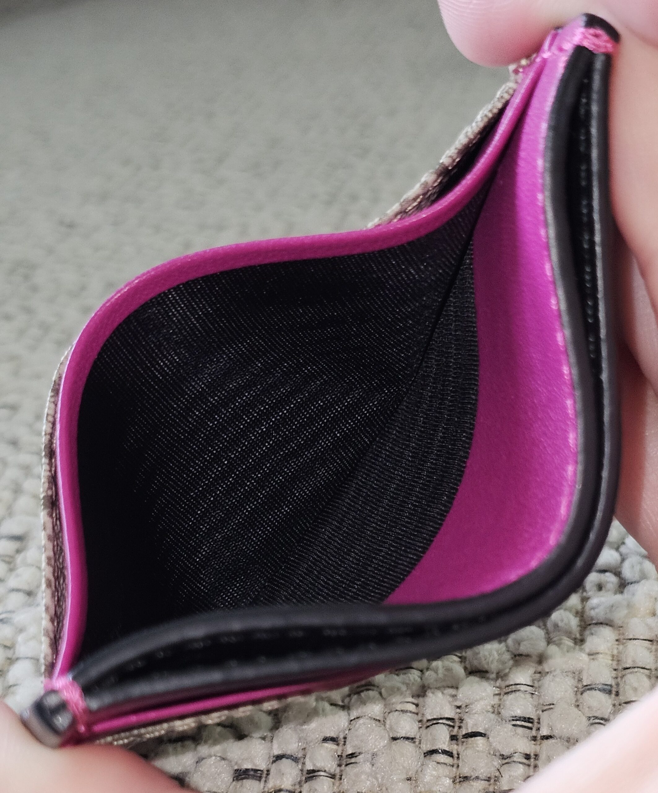 Interior of the Gucci GG Supreme Essence card holder showing the pink calfskin and clean black lining