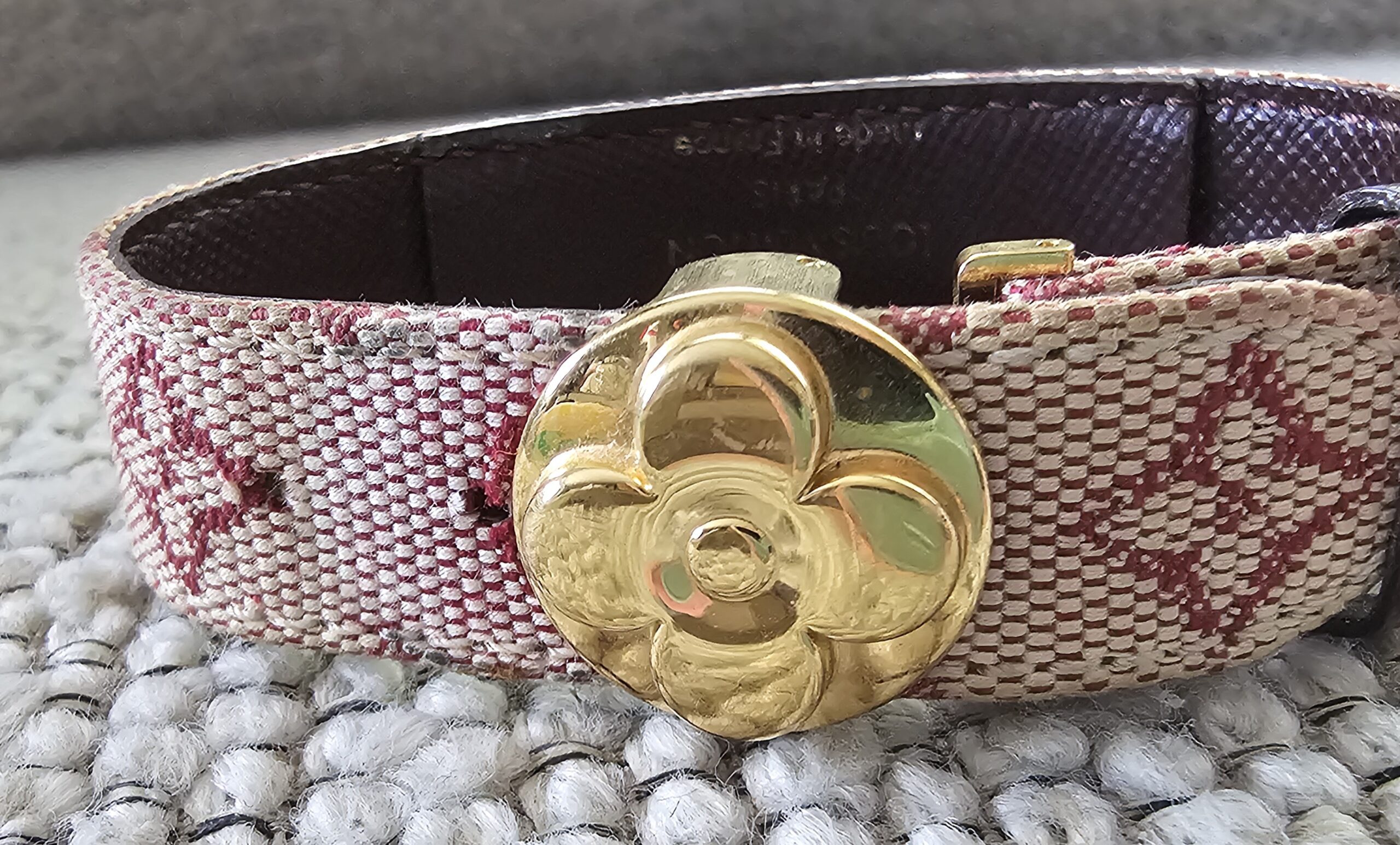 Gold-tone LV flower closure on the Louis Vuitton Monogram Mini Lin Millennium Wish bracelet