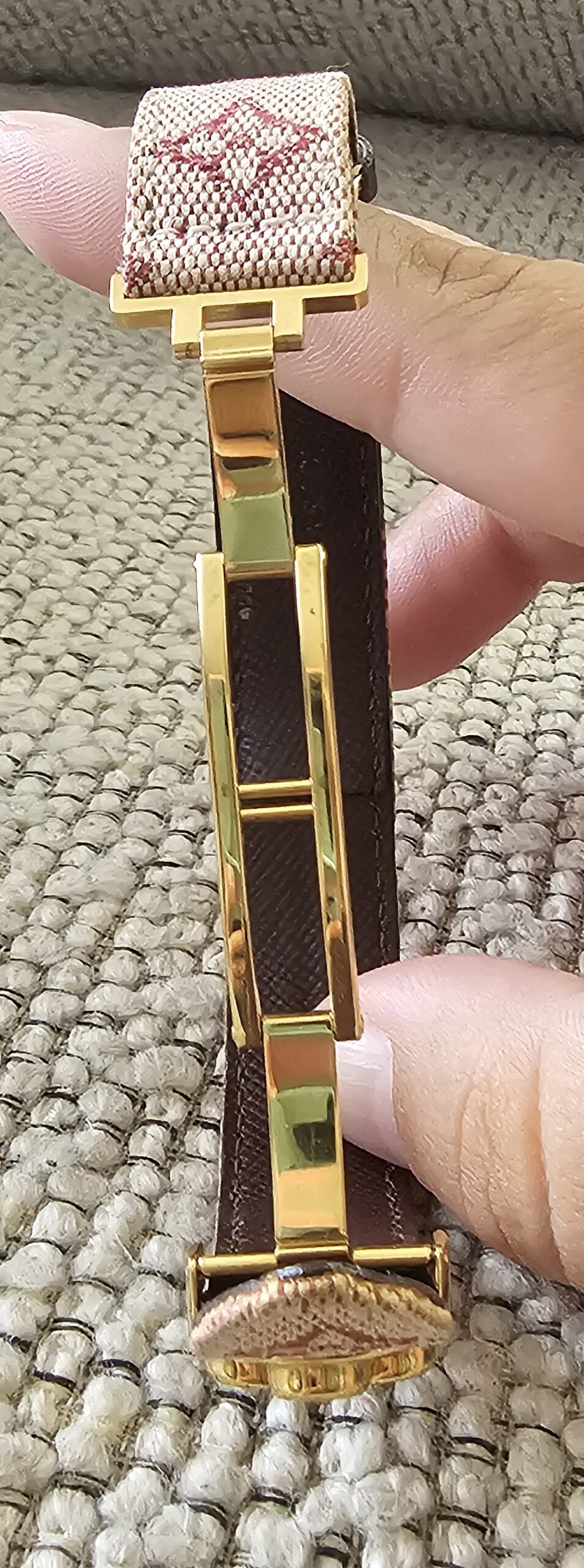 Louis Vuitton Millennium Wish bracelet held open showing the adjustable gold-tone fastening