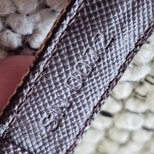 Burgundy leather lining of the Louis Vuitton Monogram Mini Lin Millennium Wish bracelet shown for wear