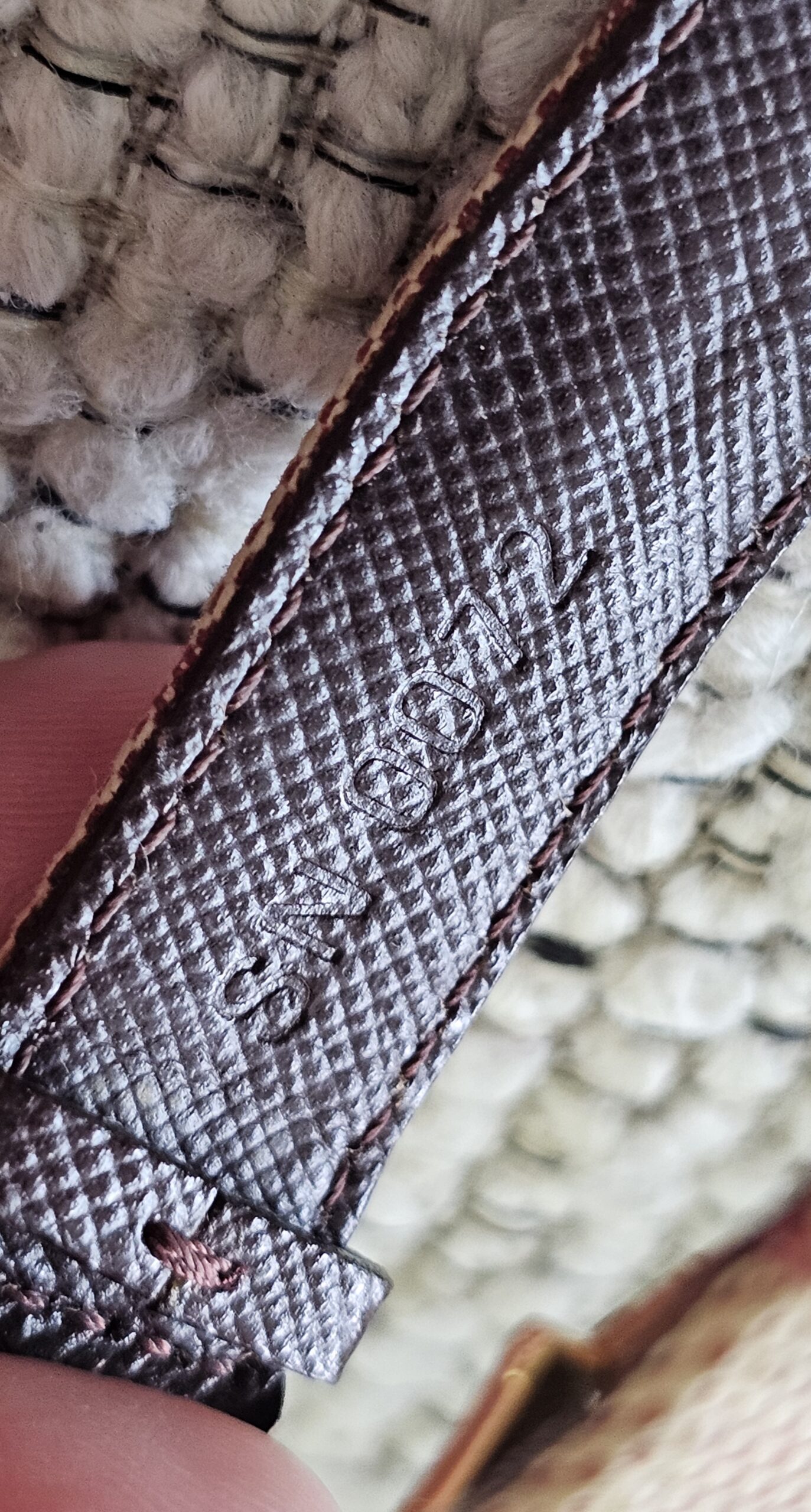 Burgundy leather lining of the Louis Vuitton Monogram Mini Lin Millennium Wish bracelet shown for wear