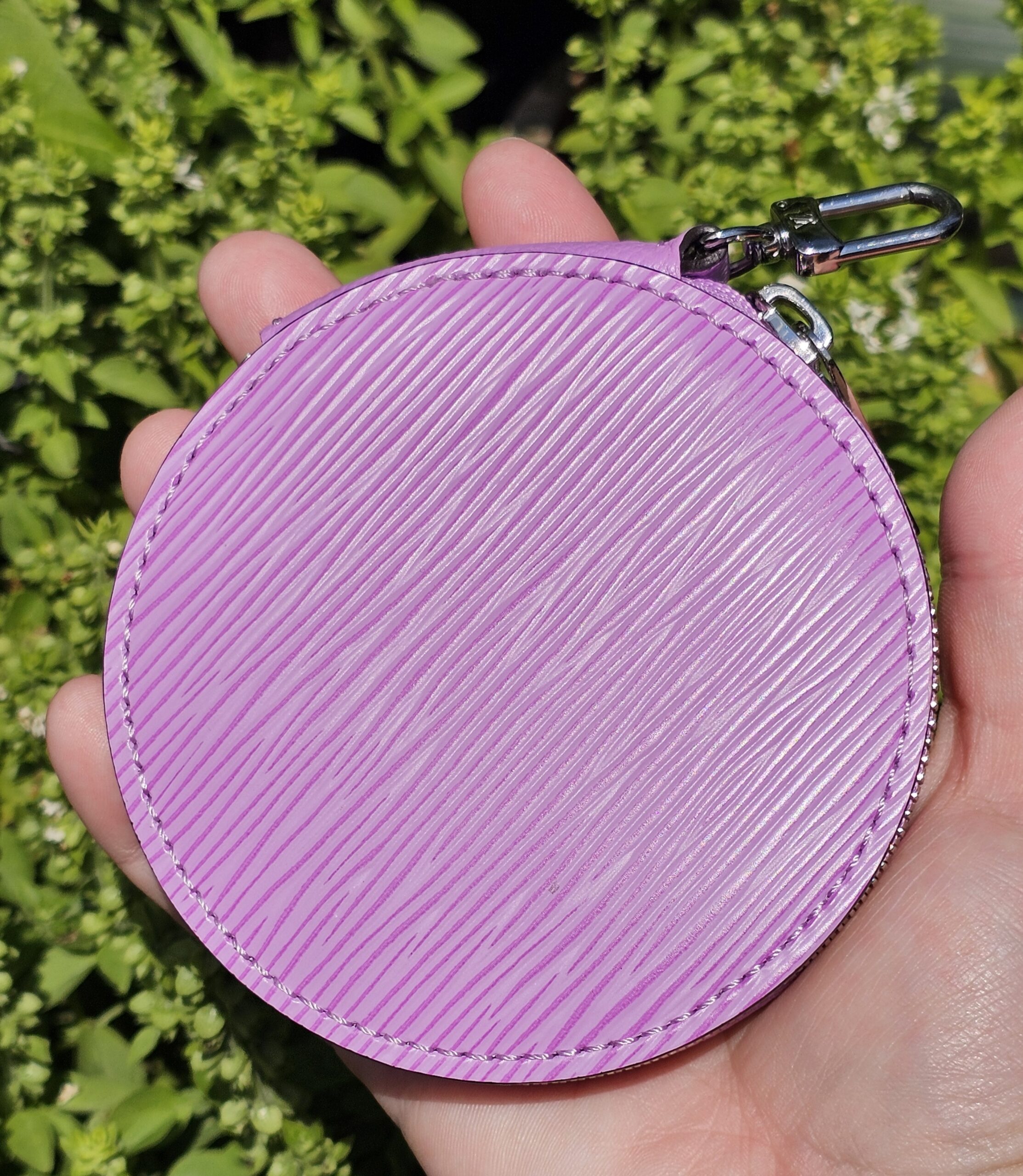 Matching round Louis Vuitton coin pouch in purple Epi leather held in hand
