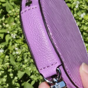 Side profile of the round purple Epi coin pouch from the Louis Vuitton Marellini set