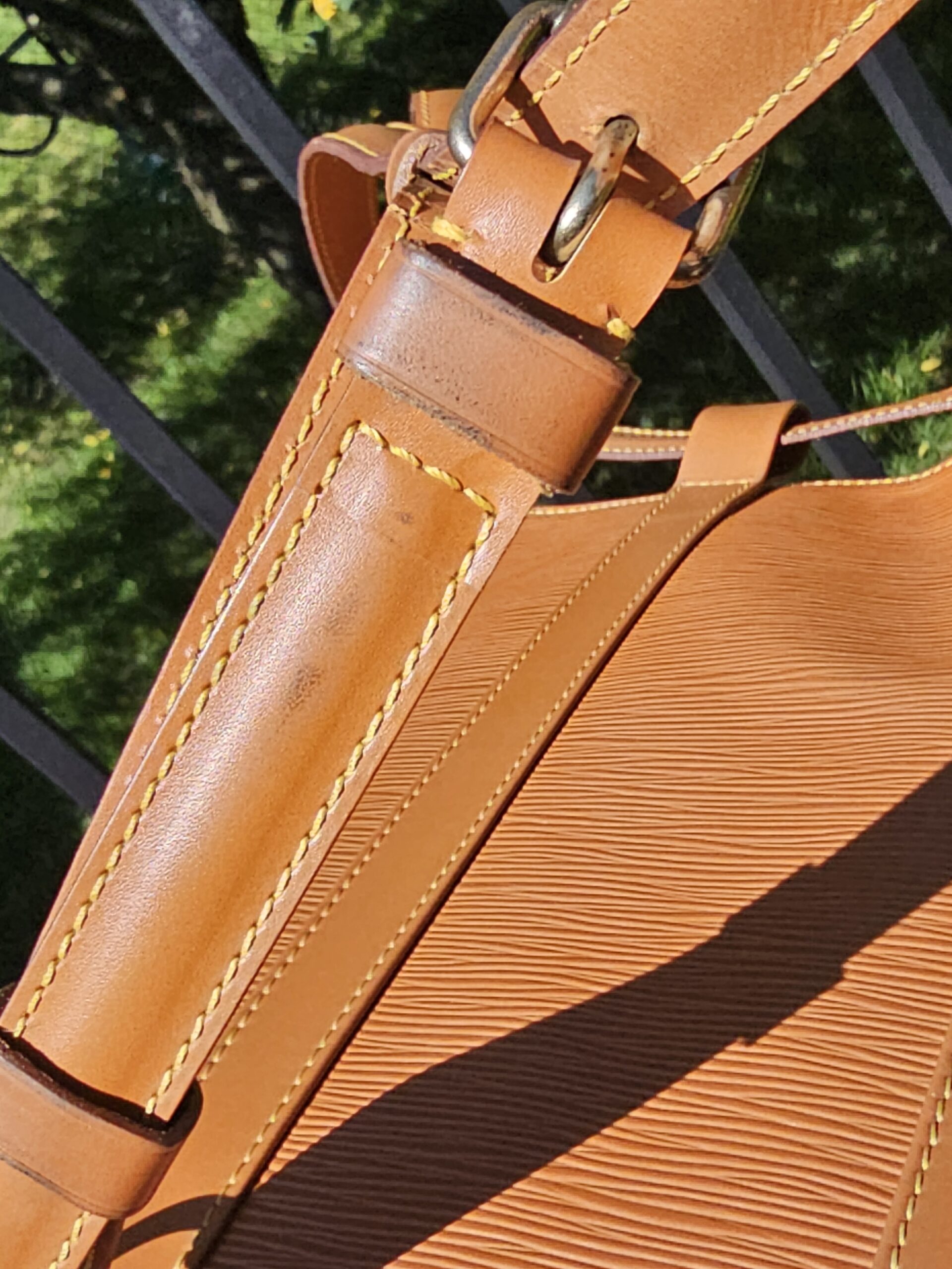 Gold-tone buckle hardware on the cinch closure of the Louis Vuitton Epi Randonnee PM