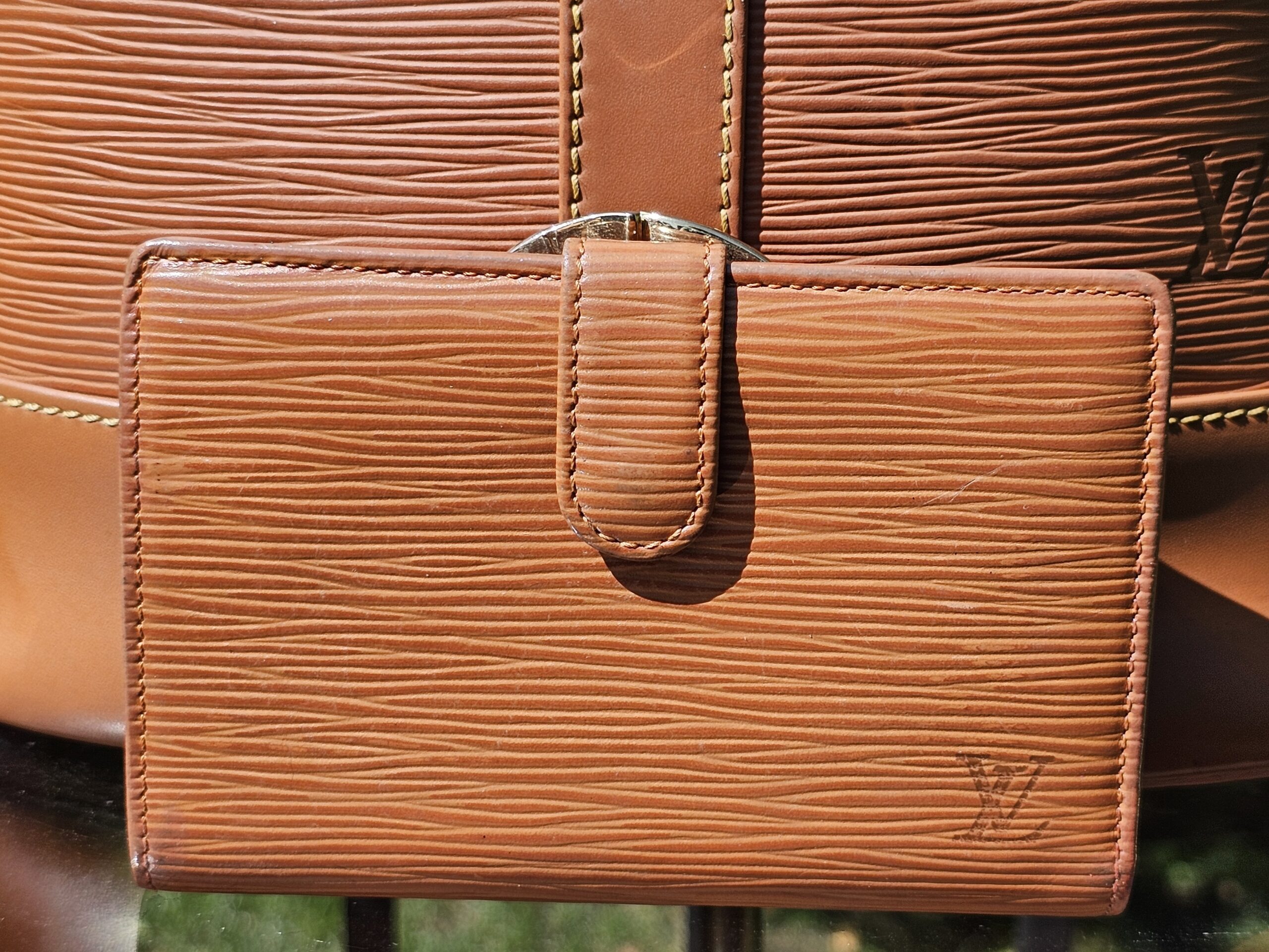 Front of the coordinating Louis Vuitton Epi kisslock wallet in Cipango Gold
