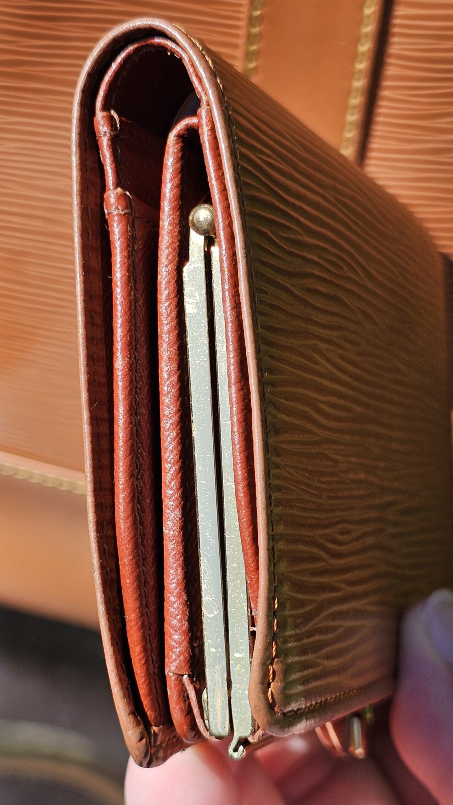 Interior of the Louis Vuitton Epi kisslock wallet showing card slots and bill compartments