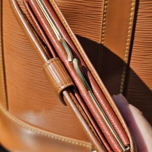 Louis Vuitton Epi kisslock wallet held open showing its compartments