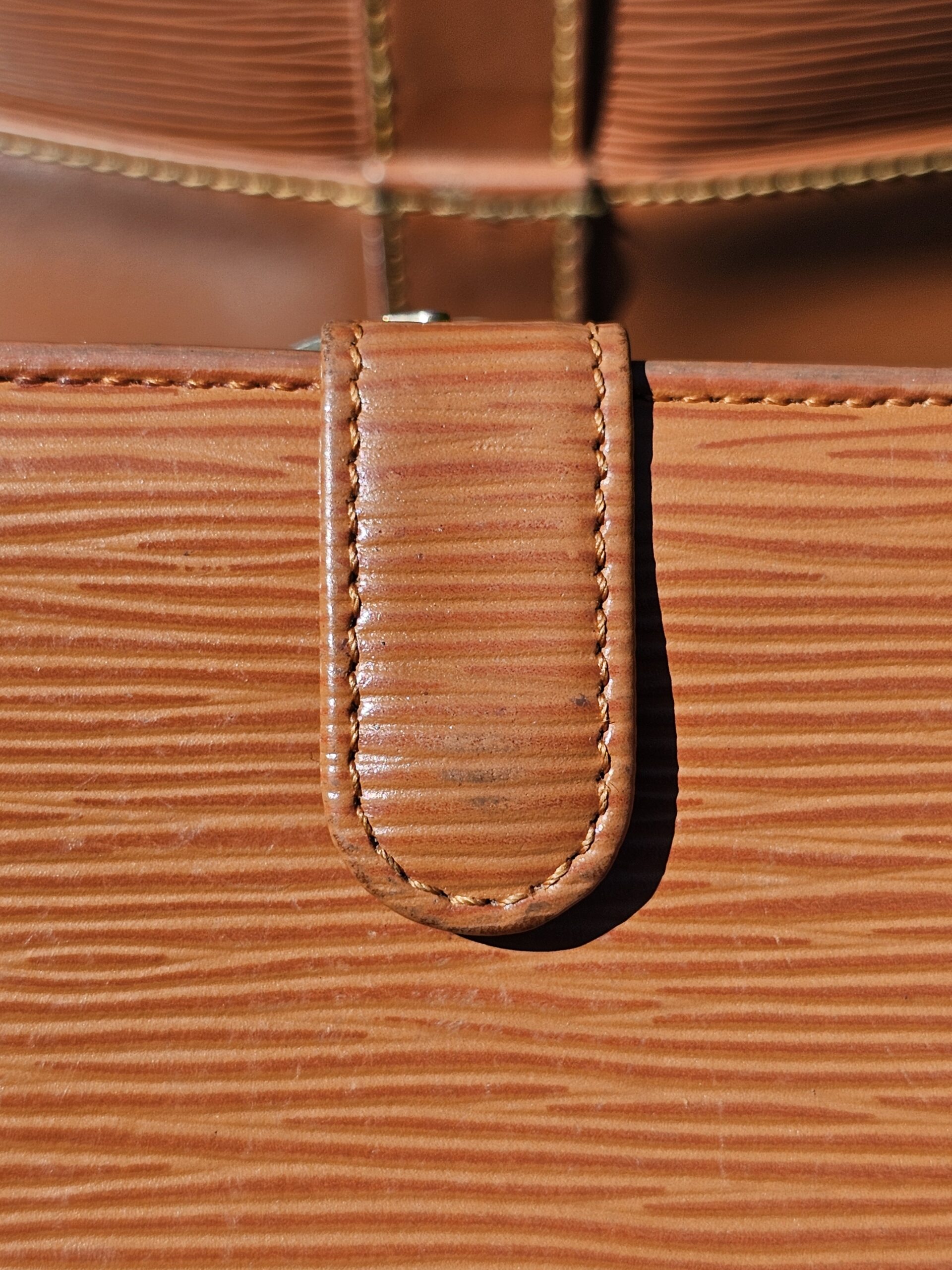 Close-up of the Cipango Gold Epi leather grain on the kisslock wallet