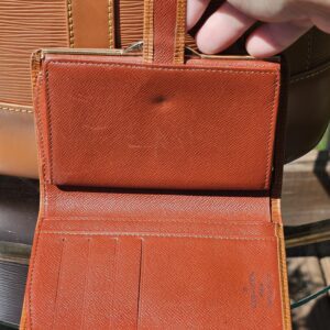 Interior leather of the Louis Vuitton Epi kisslock wallet shown for vintage wear