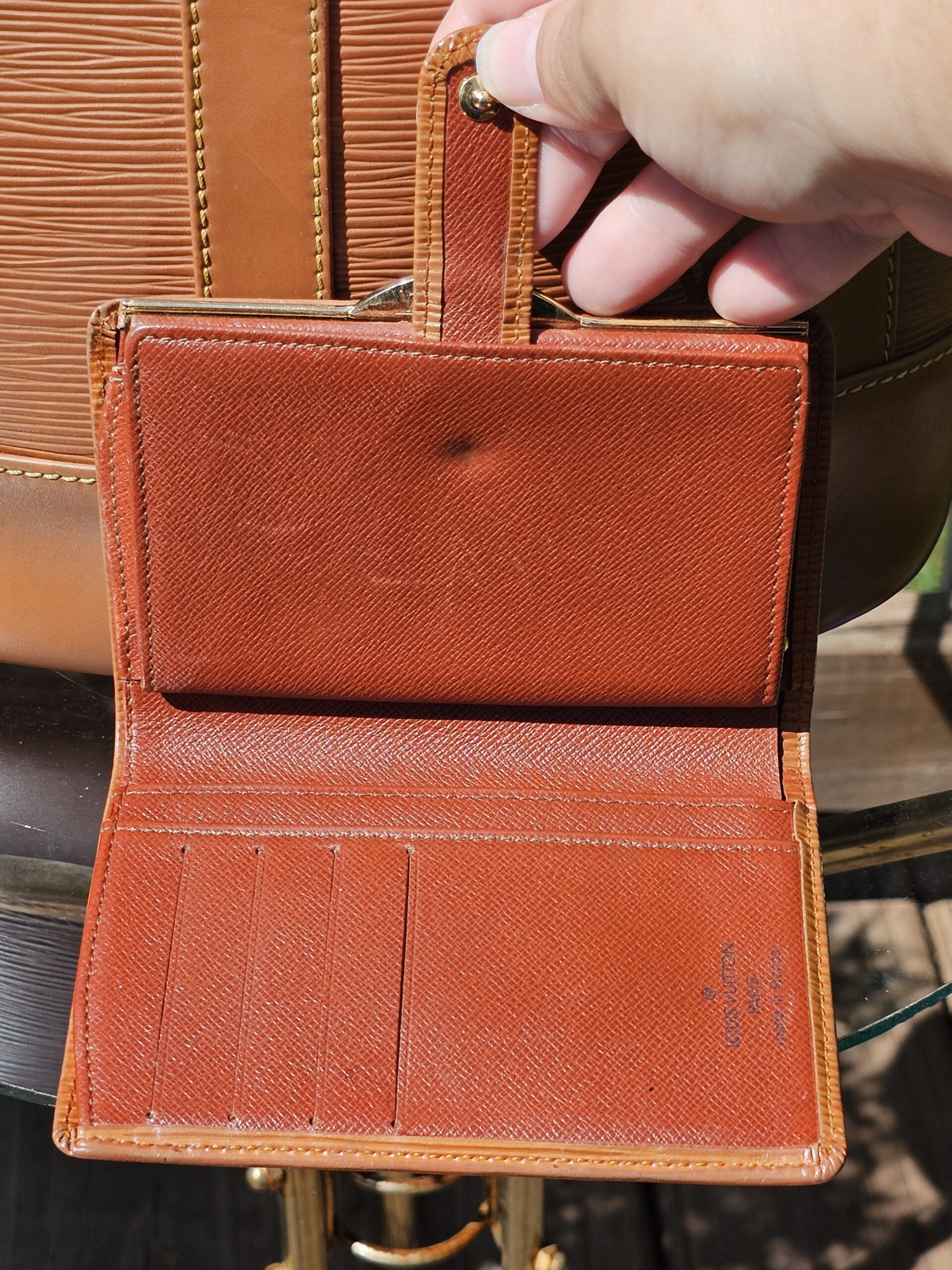 Interior leather of the Louis Vuitton Epi kisslock wallet shown for vintage wear