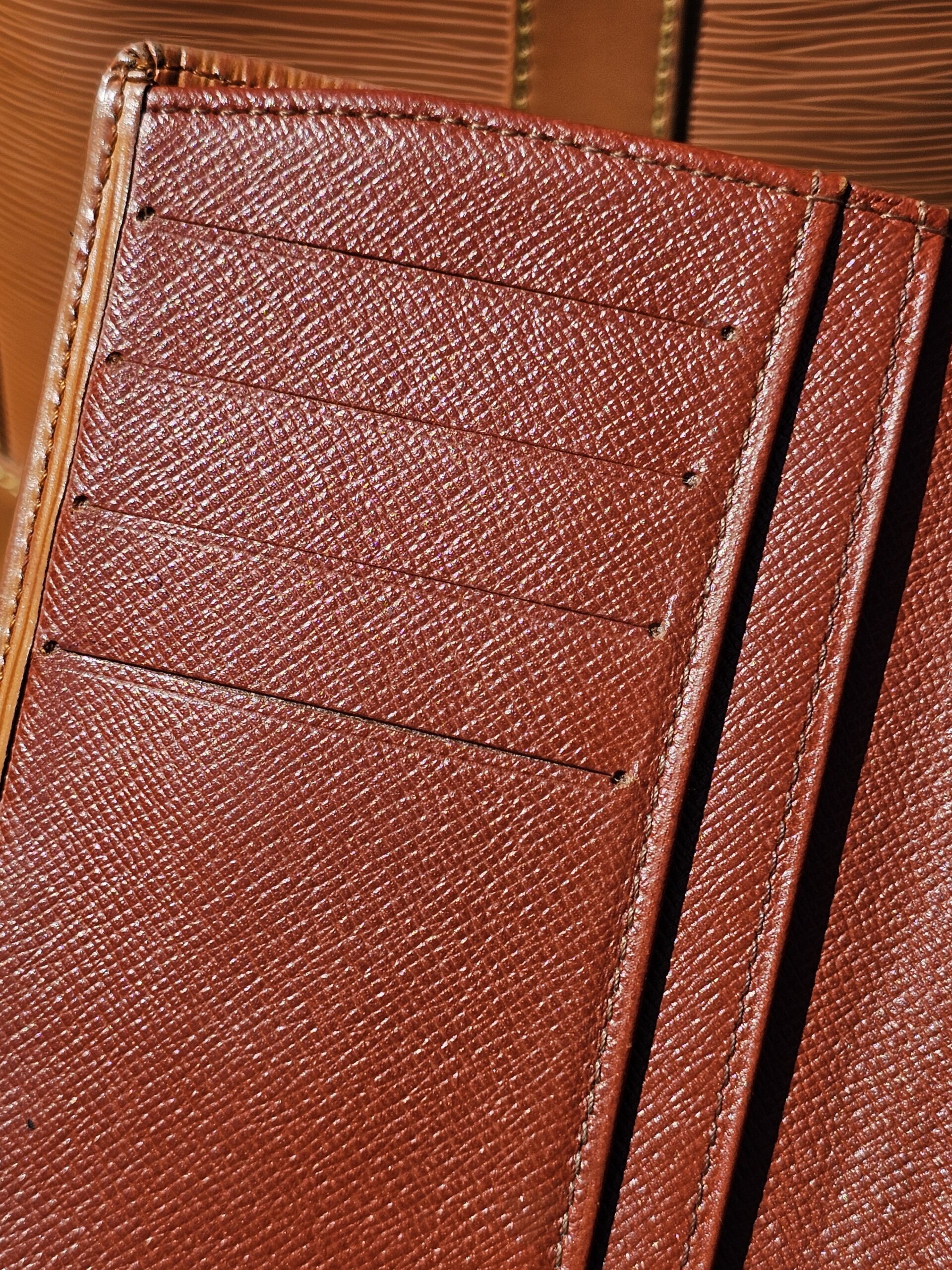 Card pockets and Louis Vuitton stamp inside the Epi kisslock wallet