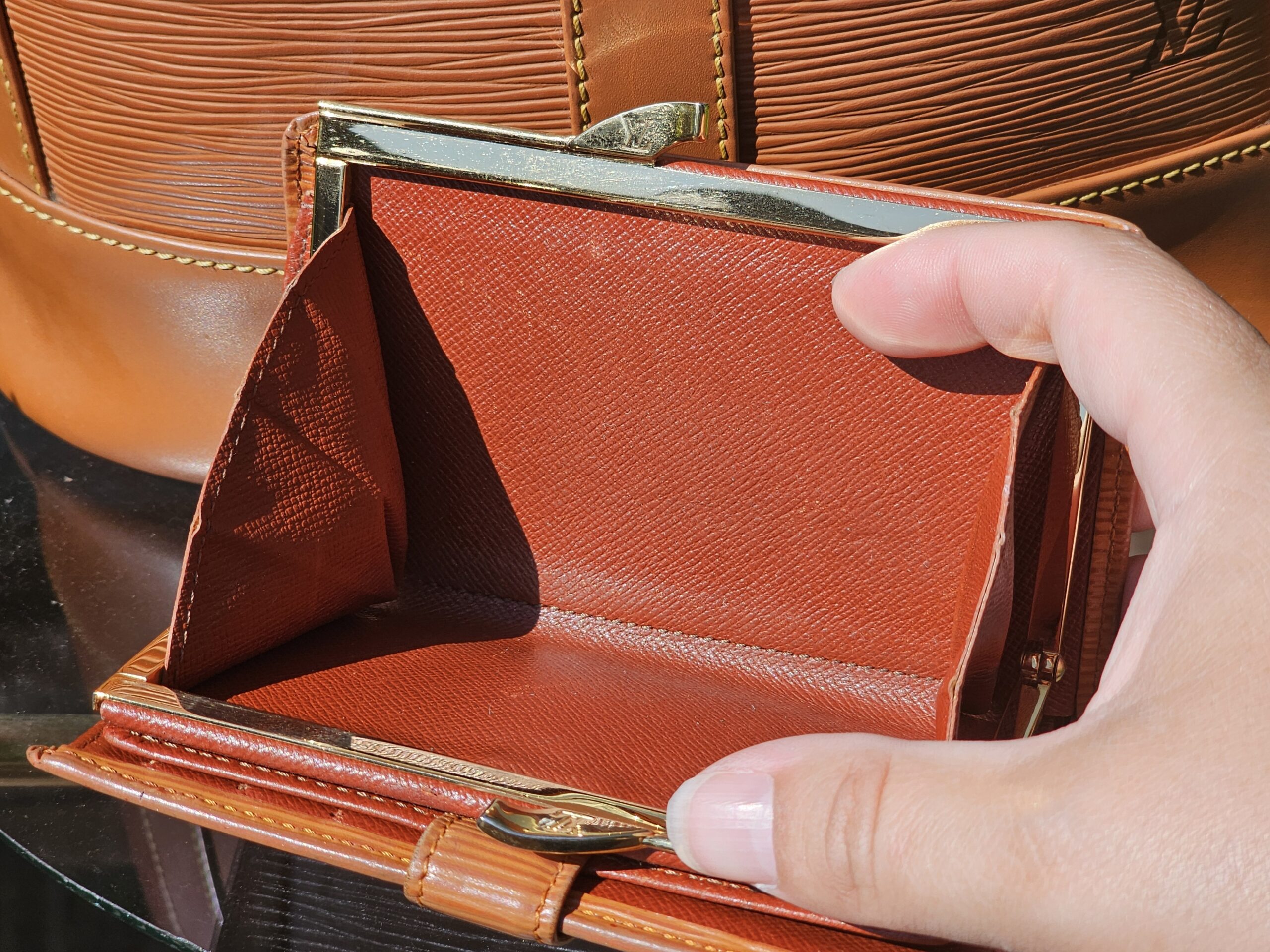 Brass kisslock frame and coin compartment of the Louis Vuitton Epi wallet