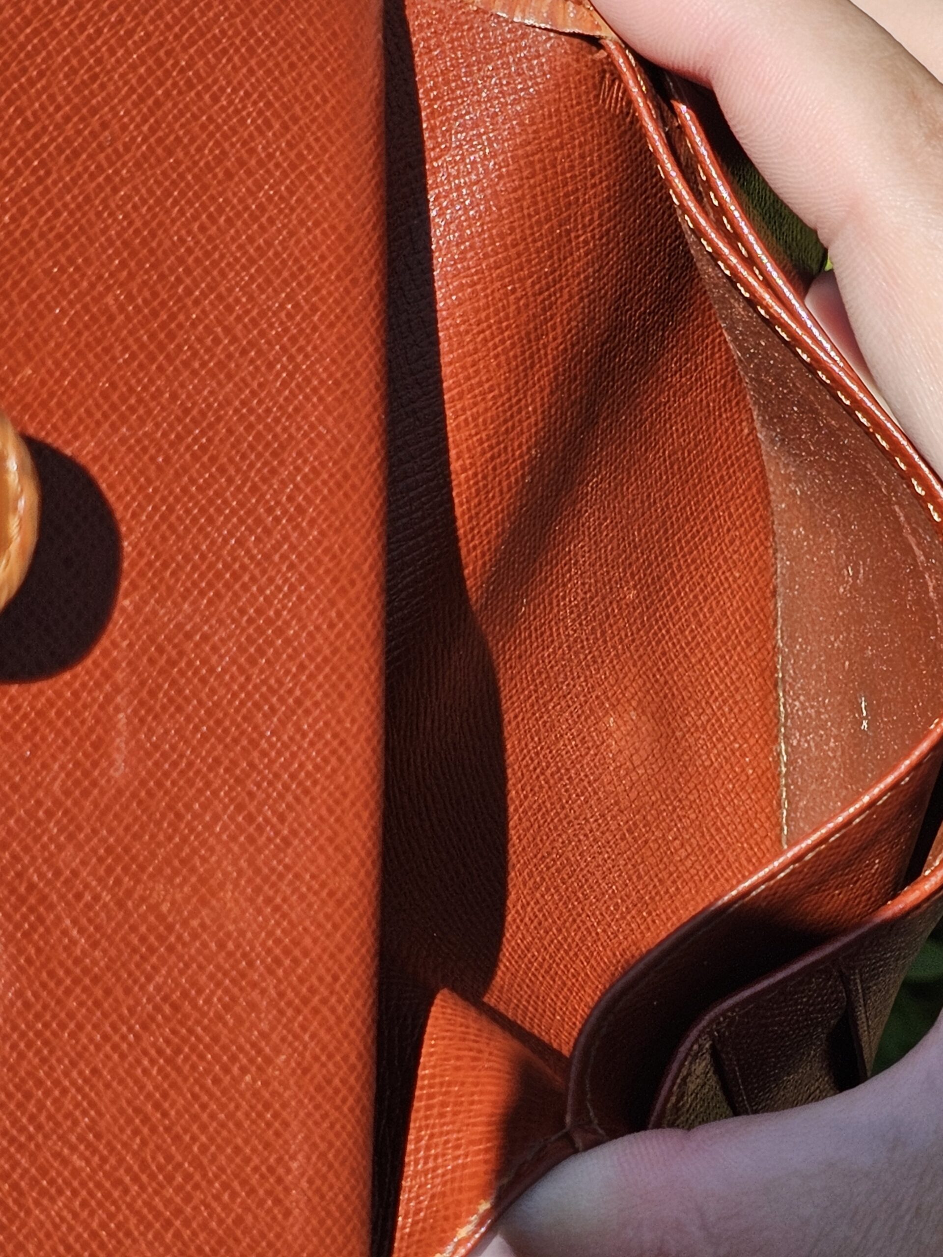 Pocket lining inside the Louis Vuitton Epi kisslock wallet shown for condition