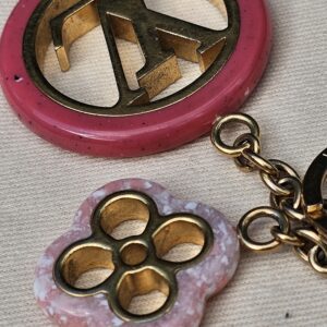 Close-up of the pink resin LV medallion and pale floral charm on the Louis Vuitton Colorline bag charm
