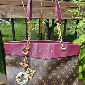 Louis Vuitton Insolence key holder and bag charm hanging from a Monogram tote, shown for scale and styling