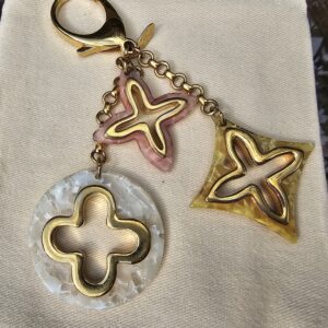 Full view of the Louis Vuitton Insolence bag charm showing the lobster clasp, chain and all three resin charms