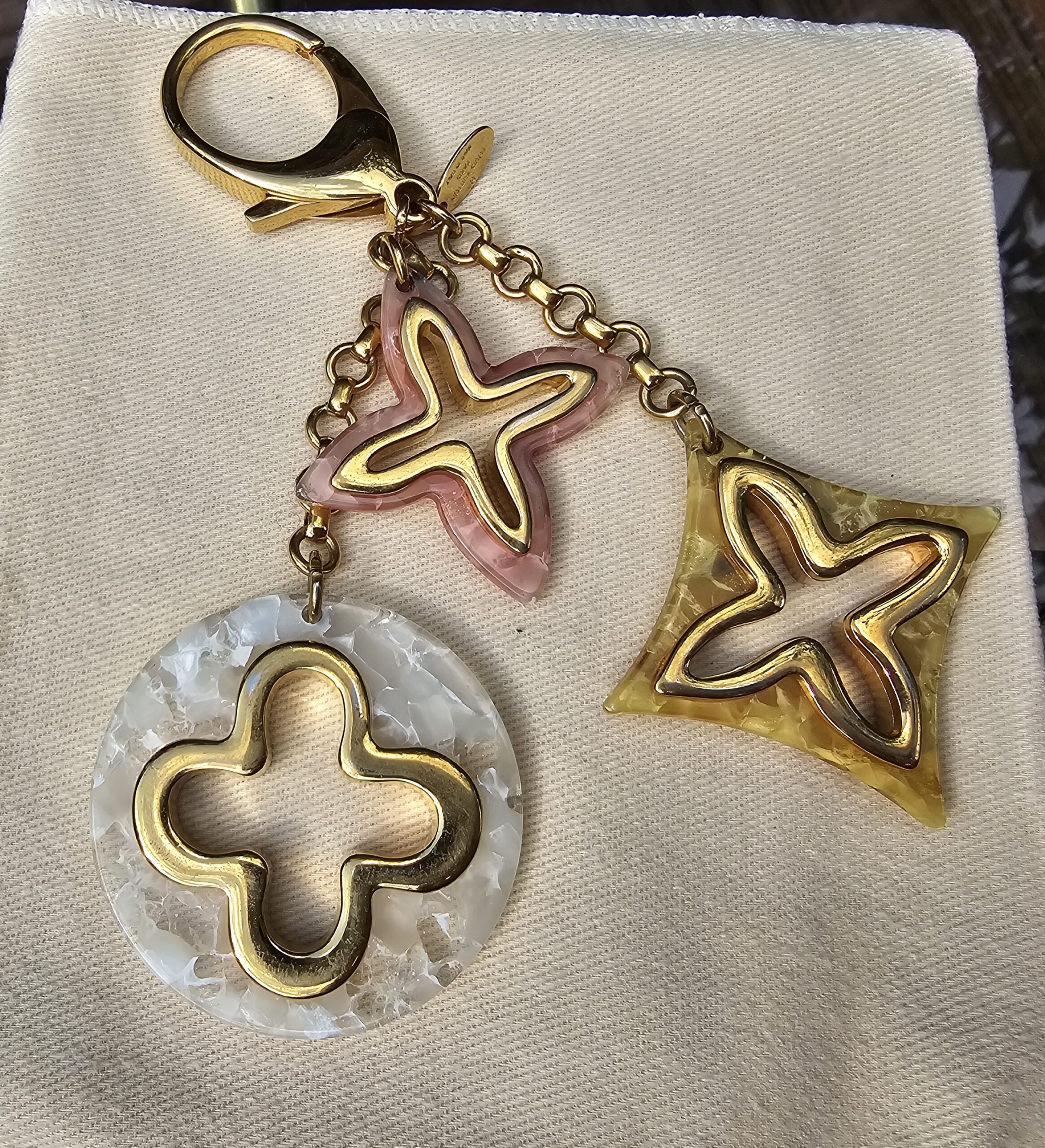 Full view of the Louis Vuitton Insolence bag charm showing the lobster clasp, chain and all three resin charms