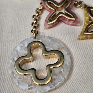 Pearly white resin medallion with a gold-tone Monogram flower on the Louis Vuitton Insolence bag charm