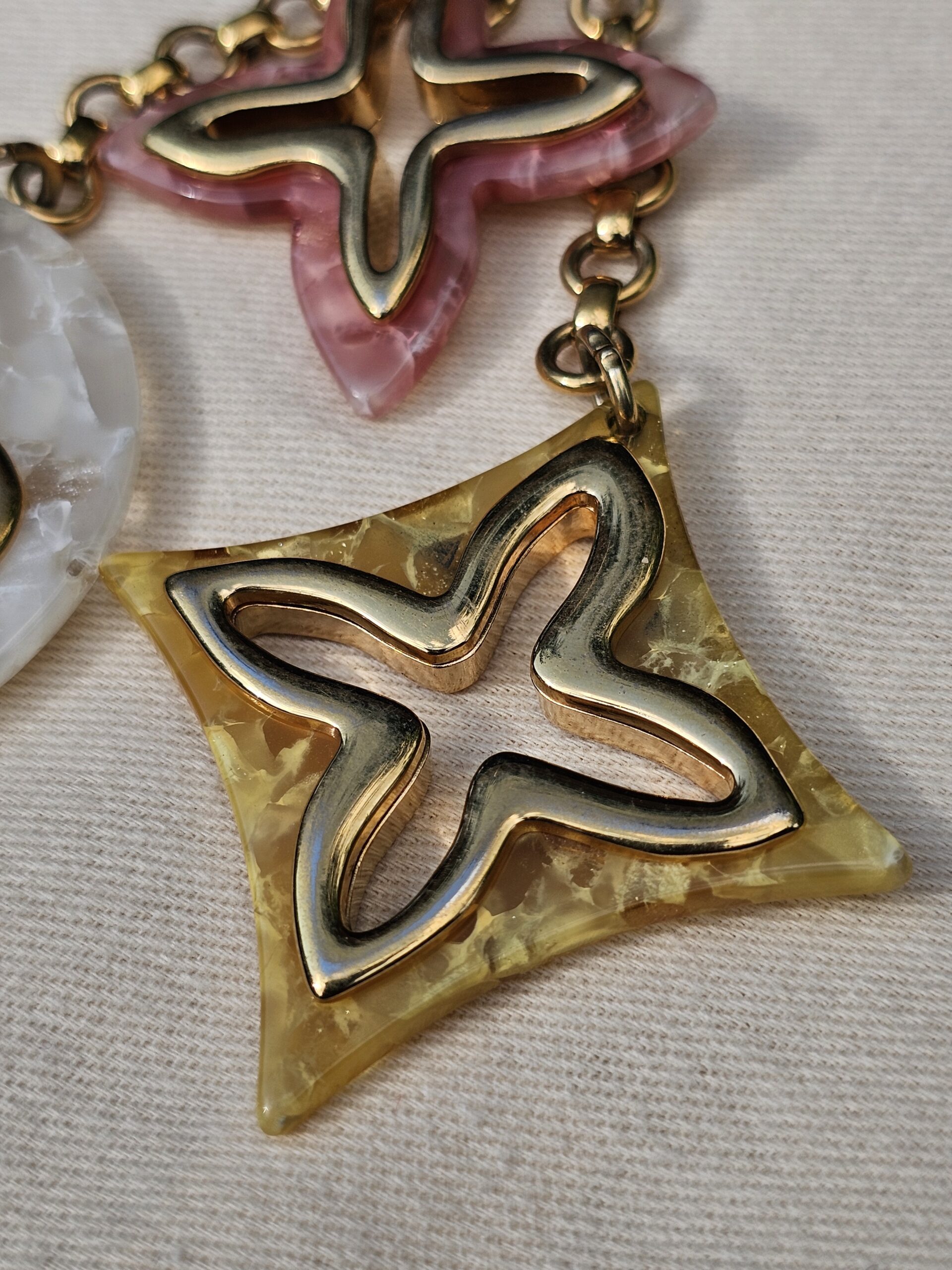 Pink marbled star and golden yellow diamond resin charms on the Louis Vuitton Insolence bag charm